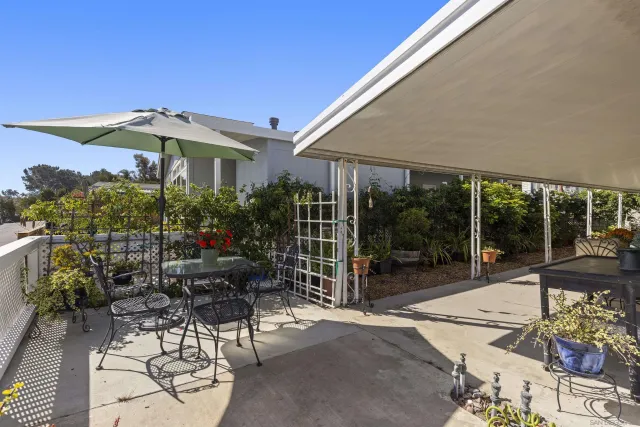 a patio with a table and chairs under an umbrella