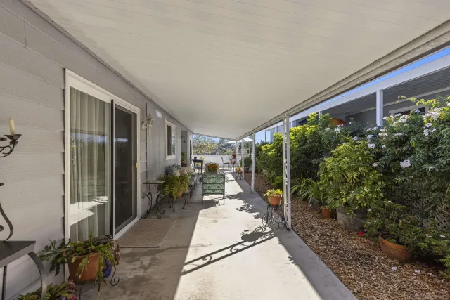 a porch with seating space and trees in the background