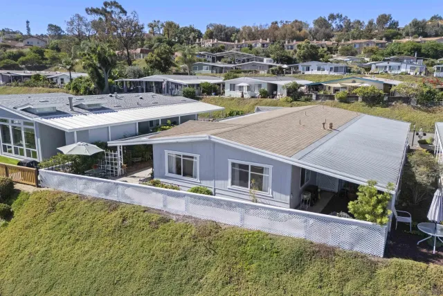 a view of a house with pool and trees in the background