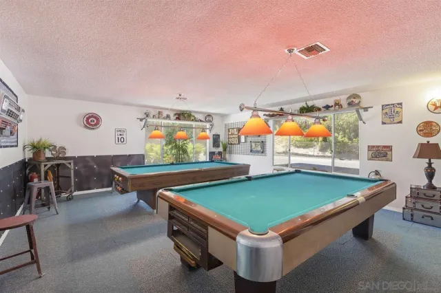 a room with pool table table soccer and windows