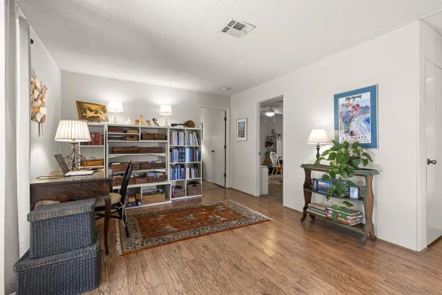 a view of a workspace with furniture and wooden floor
