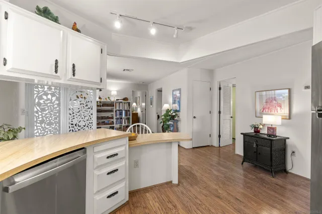 a view of kitchen with stainless steel appliances kitchen island granite countertop a sink and wooden floors