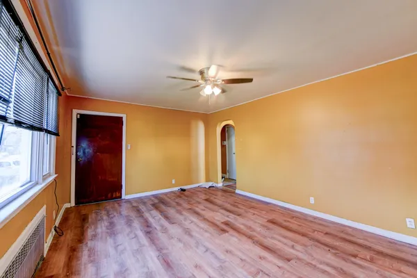 a view of a big room with windows and chandelier fan