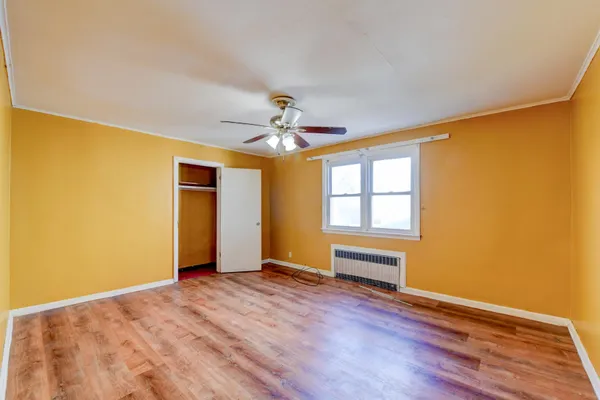 a view of a livingroom with wooden floor and a ceiling fan