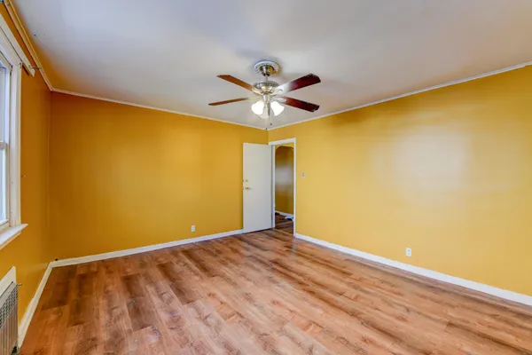 a view of an empty room with window and a ceiling fan