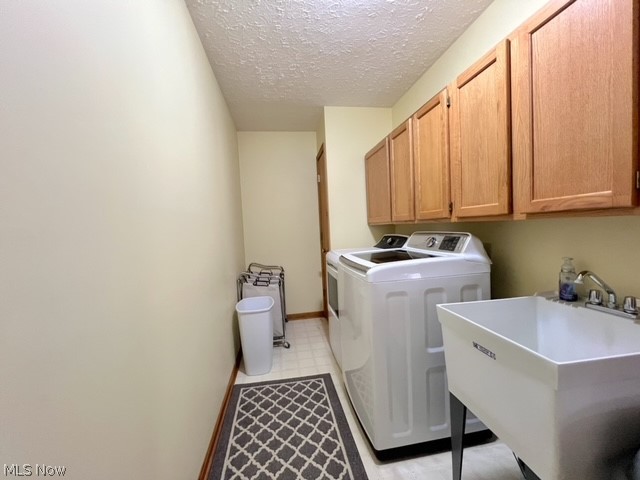 1349 Deer Hill Road Dennison, OH 44621 - Photo 28 of 36 Laundry room featuring sink, cabinets, a textured ceiling, light tile patterned floors, and independent washer and dryer