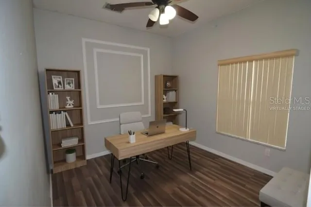 a view of a workspace with furniture and a window