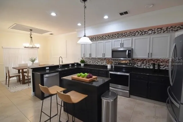 a kitchen with a refrigerator and a stove top oven