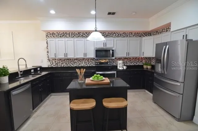 a kitchen with granite countertop a sink stove and refrigerator