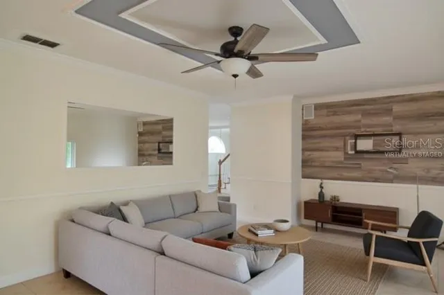 a living room with furniture and a ceiling fan