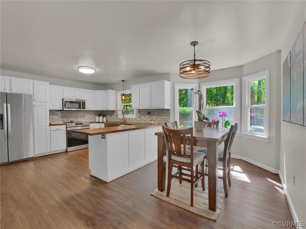 14307 Long Gate Road Midlothian, VA 23112 - Photo 16 of 41 a kitchen with a dining table chairs and refrigerator