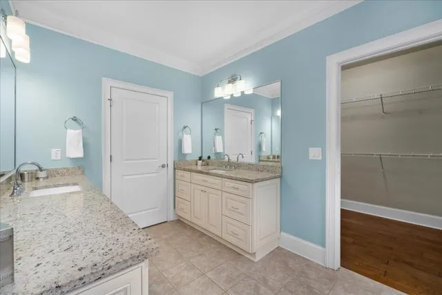 a bathroom with a granite countertop sink two mirror and shower