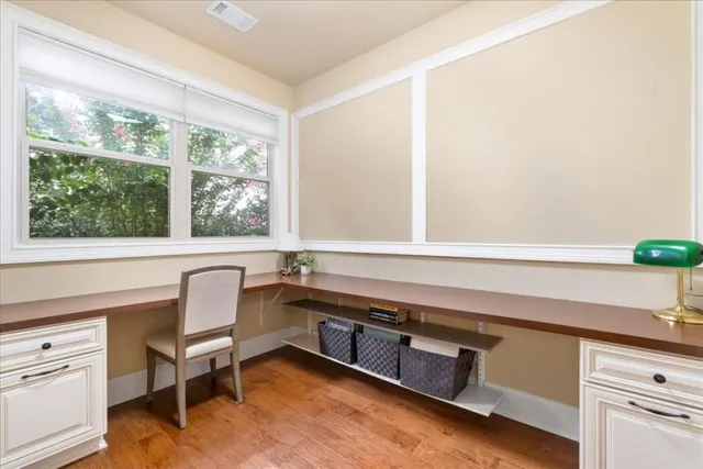 a balcony with view of dining room and wooden floor