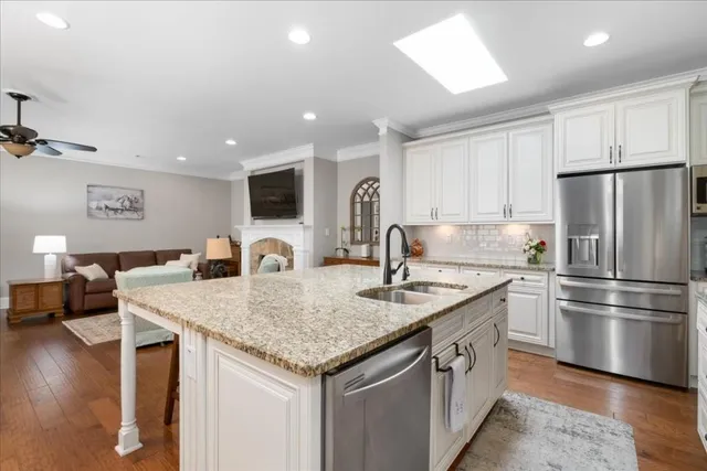 a kitchen with stainless steel appliances granite countertop a sink a refrigerator and a stove