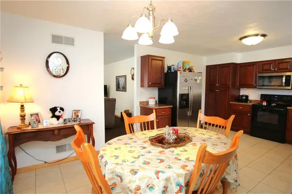 a dining room with wooden floor a chandelier a wooden table and chairs