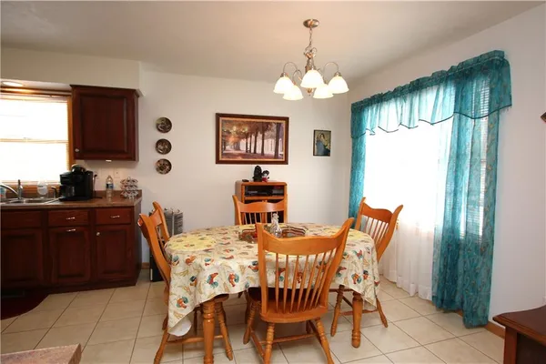 a view of a dining room with furniture a chandelier and window