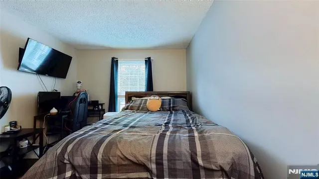 a bedroom with a bed and flat screen tv