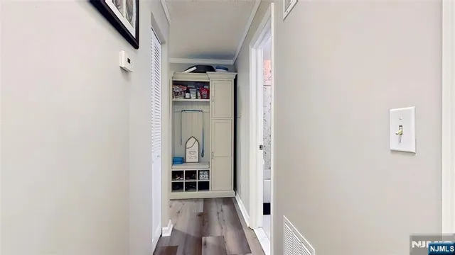 a view of a hallway with wooden floor and entryway