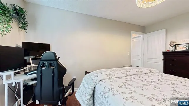 a bedroom with a bed and a flat tv screen on dresser