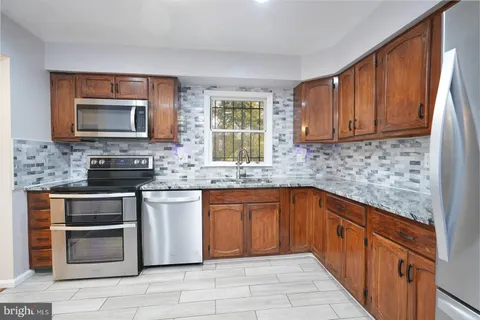 a kitchen with stainless steel appliances granite countertop a stove sink and microwave