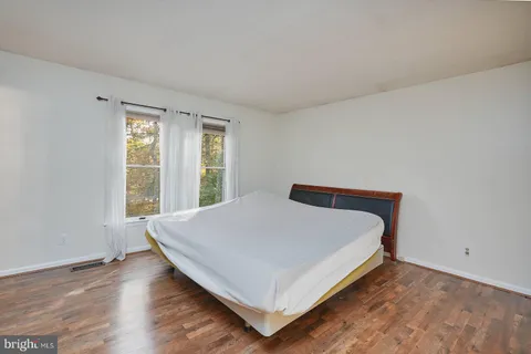 a bed sitting in a bedroom next to a window