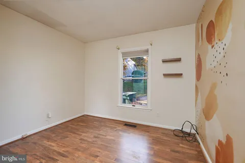 a view of a room with wooden floor and a window