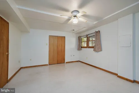 a view of an empty room with a chandelier fan