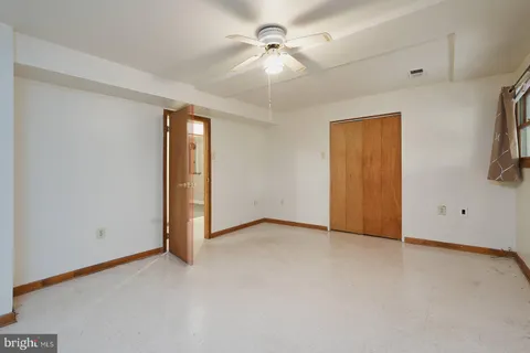 an empty room with windows and a ceiling fan