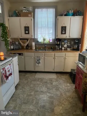 a kitchen with stainless steel appliances a stove a microwave a sink and cabinets
