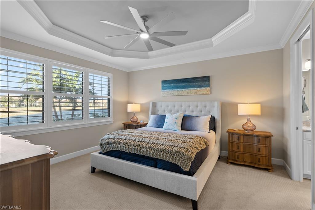 9684 Montelanico Loop, Unit 101 Naples, FL 34119 - Photo 14 of 49 Carpeted bedroom featuring a raised ceiling, ceiling fan, and crown molding