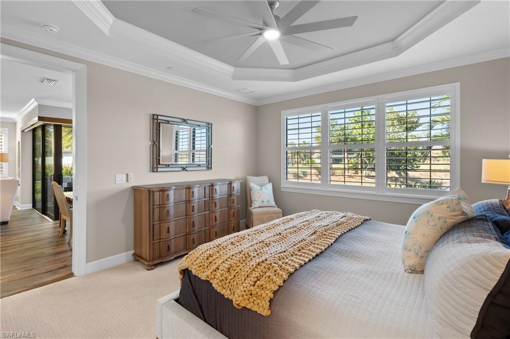 9684 Montelanico Loop, Unit 101 Naples, FL 34119 - Photo 16 of 49 Bedroom with ceiling fan, crown molding, light carpet, and a tray ceiling