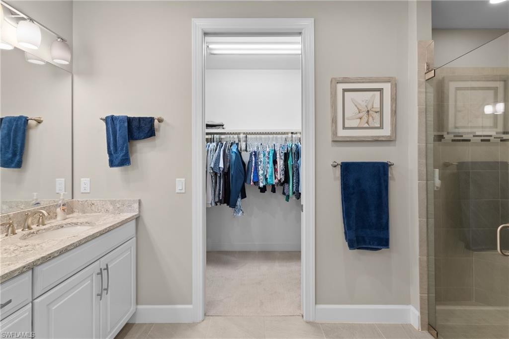 9684 Montelanico Loop, Unit 101 Naples, FL 34119 - Photo 17 of 49 Bathroom featuring tile patterned flooring, vanity, and a shower with shower door