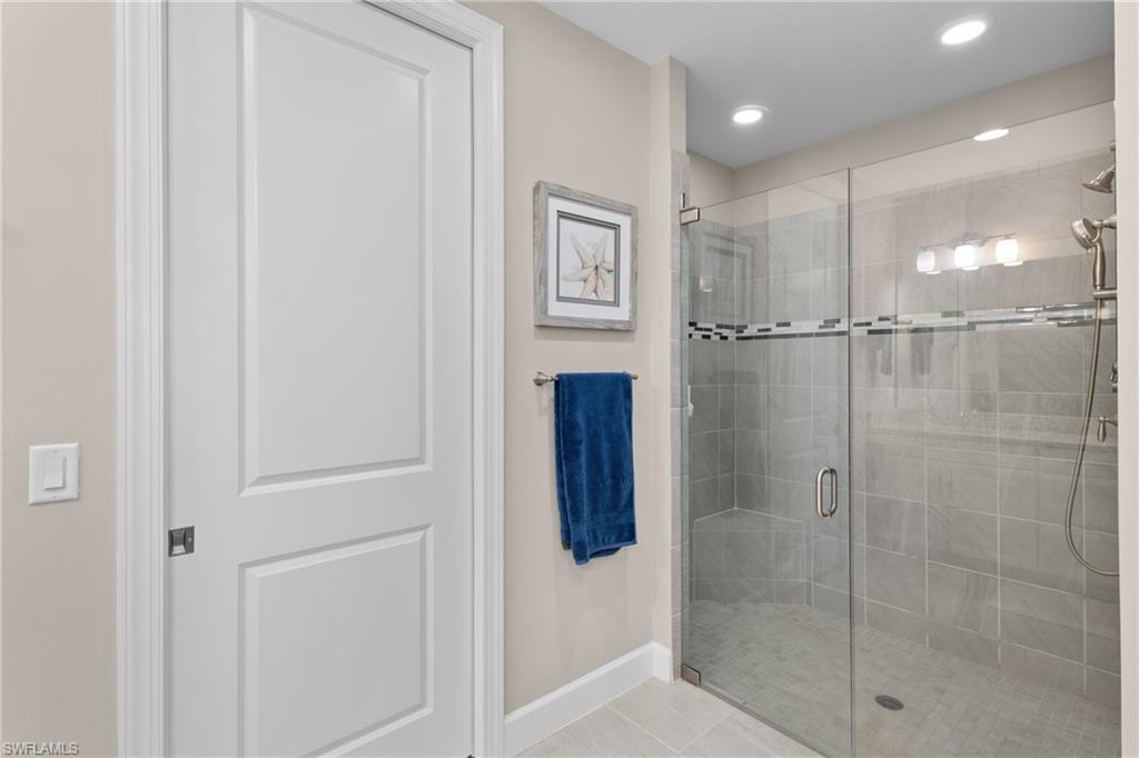 9684 Montelanico Loop, Unit 101 Naples, FL 34119 - Photo 18 of 49 Bathroom with tile patterned flooring and walk in shower
