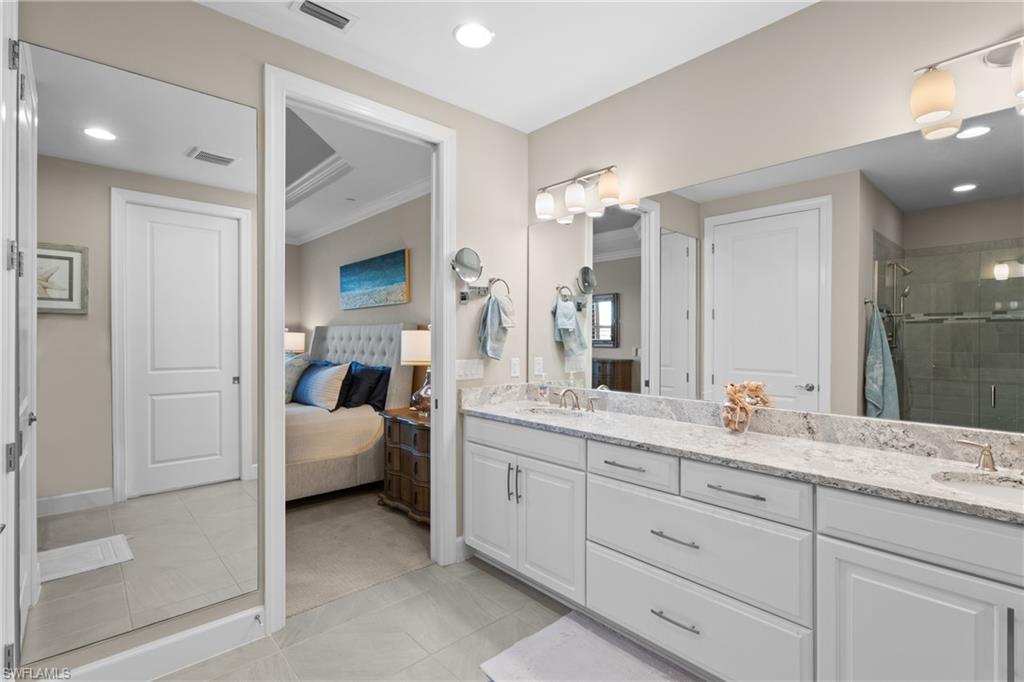 9684 Montelanico Loop, Unit 101 Naples, FL 34119 - Photo 19 of 49 Bathroom featuring vanity, a shower with shower door, and ornamental molding