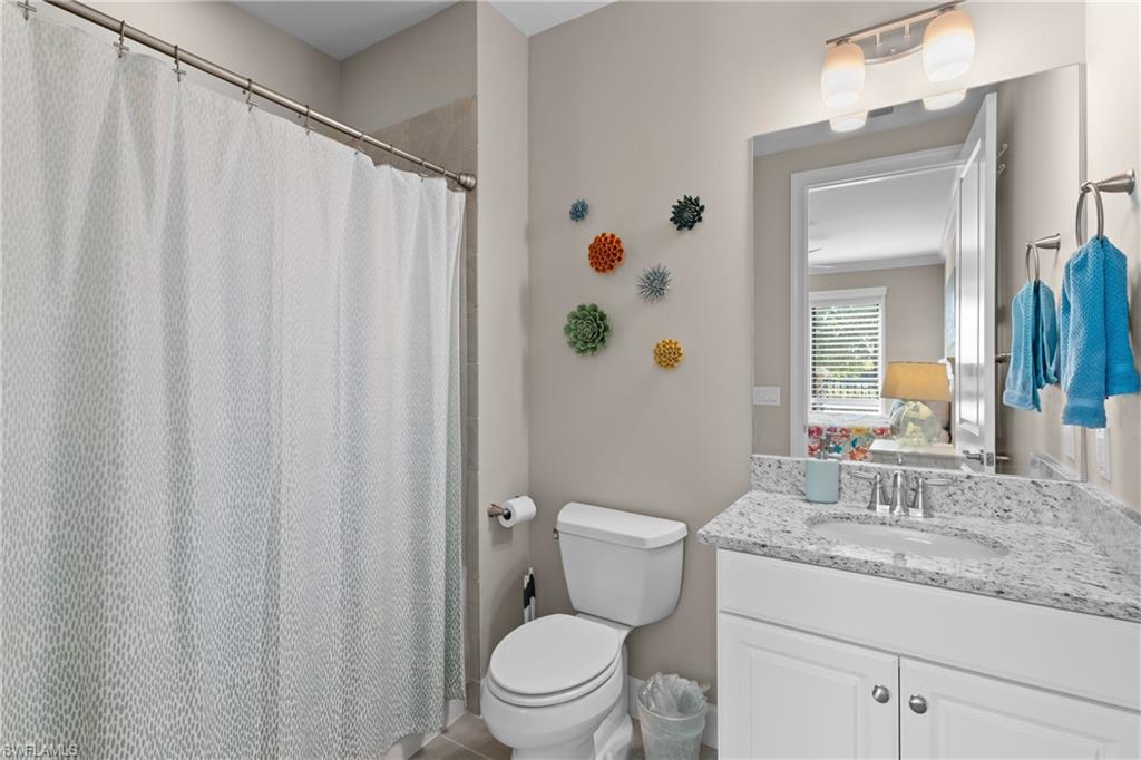 9684 Montelanico Loop, Unit 101 Naples, FL 34119 - Photo 21 of 49 Bathroom with tile patterned floors, vanity, and toilet