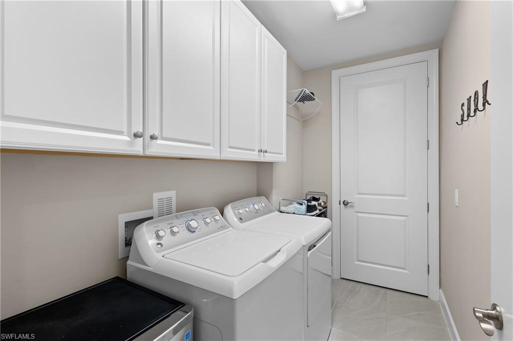 9684 Montelanico Loop, Unit 101 Naples, FL 34119 - Photo 23 of 49 Clothes washing area featuring cabinets and washing machine and dryer
