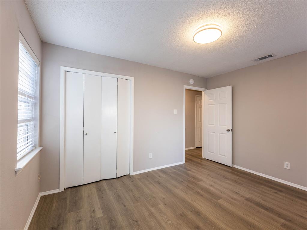 1932 Mars Drive Garland, TX 75040 - Photo 12 of 27 a view of an empty room with wooden floor and a window