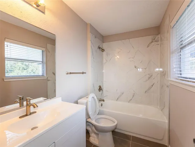 a bathroom with a sink mirror toilet and bathtub