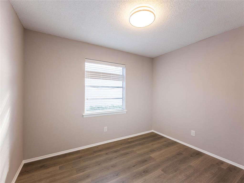 1932 Mars Drive Garland, TX 75040 - Photo 14 of 27 an empty room with wooden floor and windows