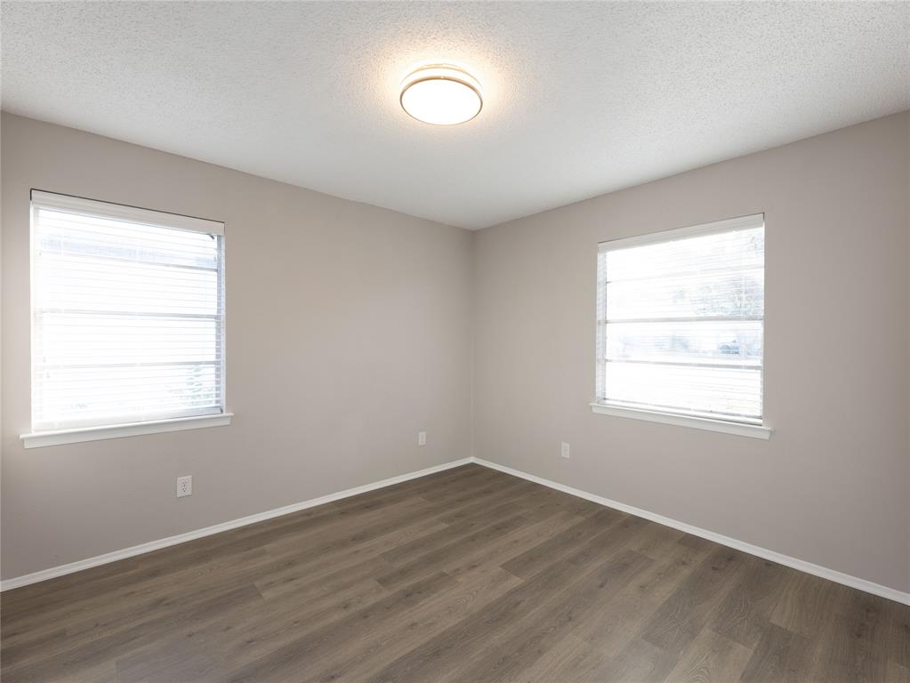 1932 Mars Drive Garland, TX 75040 - Photo 16 of 27 an empty room with wooden floor and windows