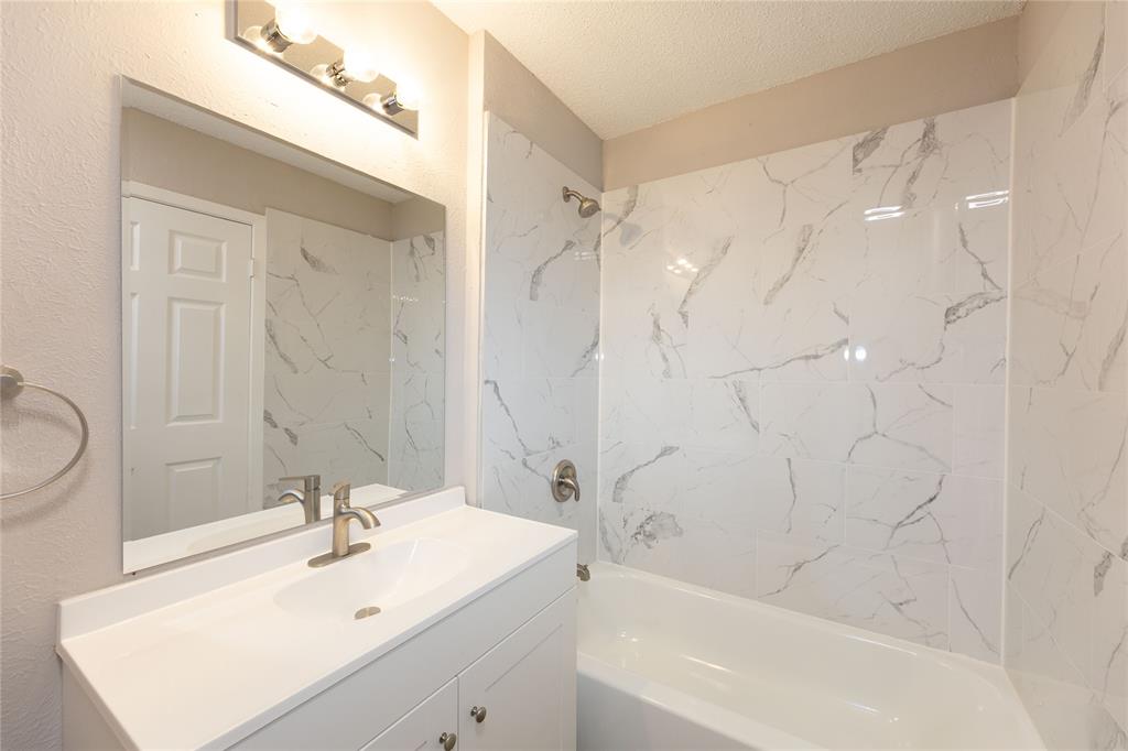 1932 Mars Drive Garland, TX 75040 - Photo 19 of 27 a bathroom with a sink a mirror and a bathtub