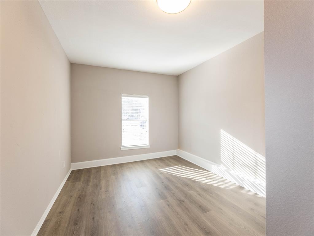 1932 Mars Drive Garland, TX 75040 - Photo 22 of 27 an empty room with wooden floor and windows