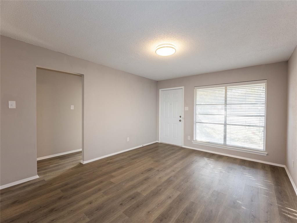1932 Mars Drive Garland, TX 75040 - Photo 4 of 27 an empty room with wooden floor and window