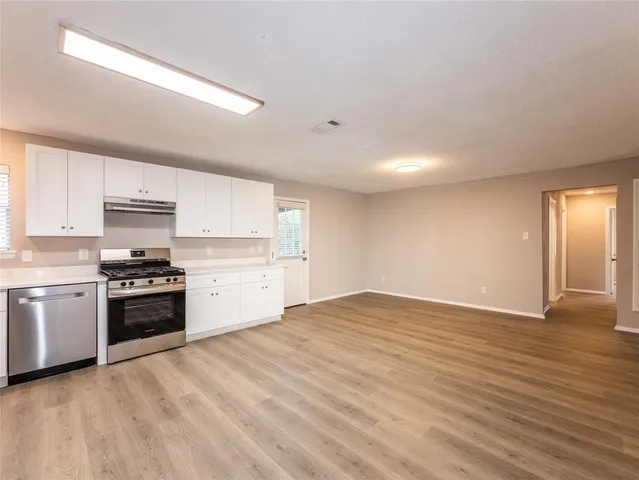 a kitchen with granite countertop a stove top oven and cabinets