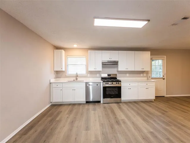 a kitchen with a white stove top oven sink and cabinets