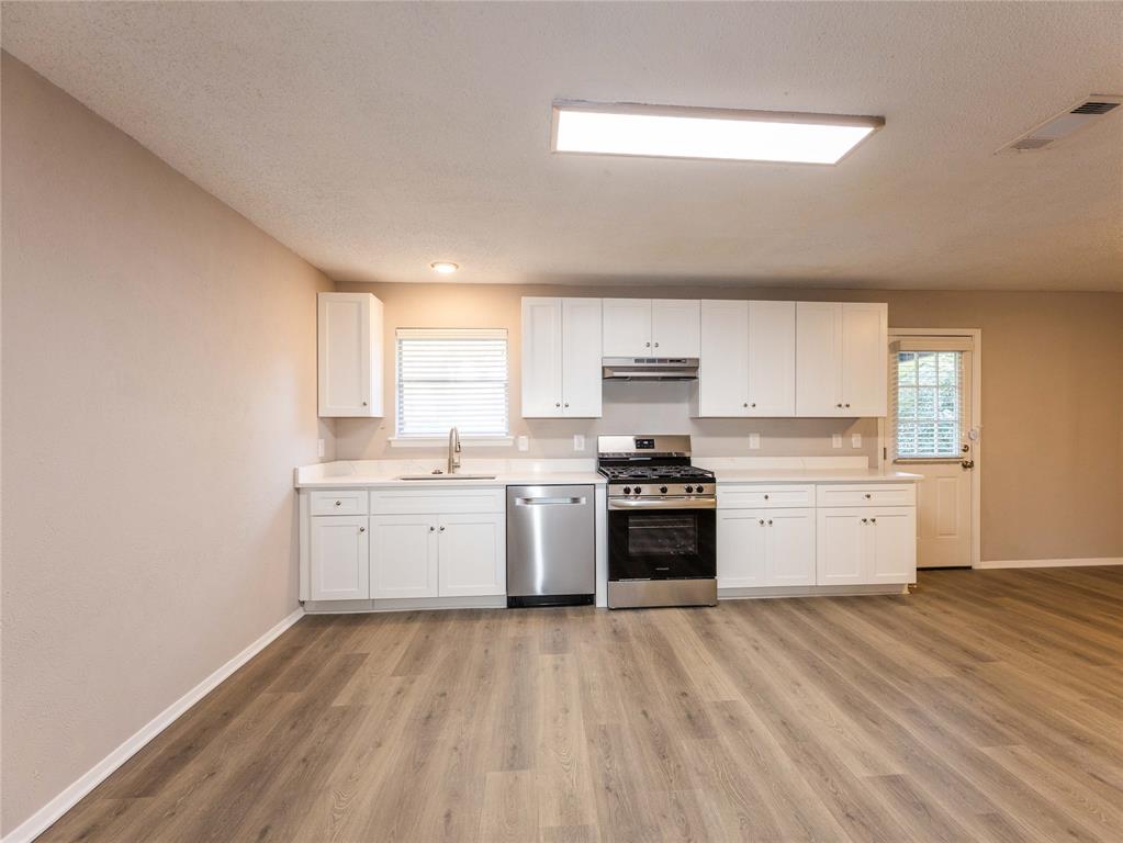 1932 Mars Drive Garland, TX 75040 - Photo 7 of 27 a kitchen with a white stove top oven sink and cabinets