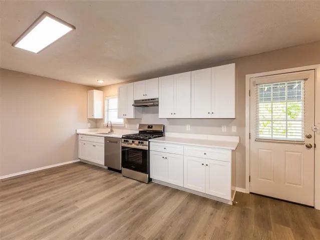 a kitchen with granite countertop white cabinets and white appliances