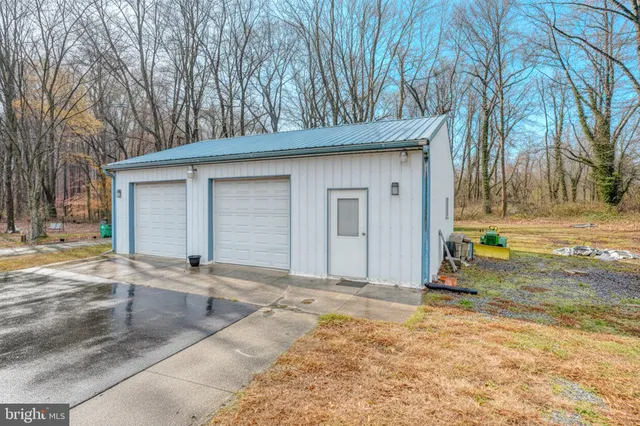 a view of a house with a yard and large tree