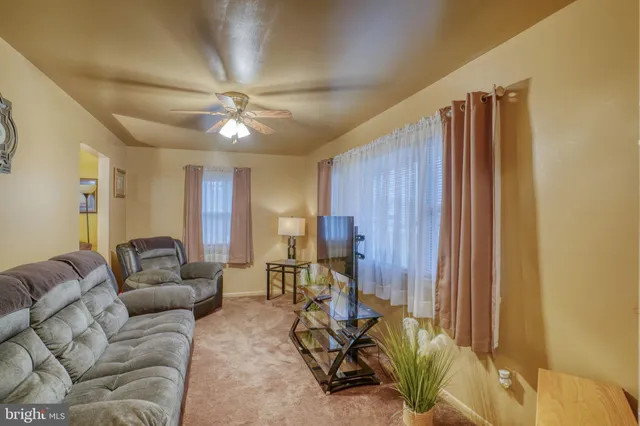 a living room with furniture a two sinks and a ceiling fan