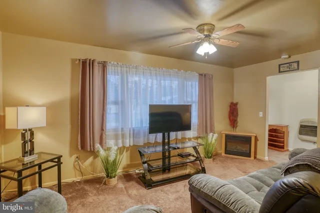 a living room with furniture a fireplace and a window